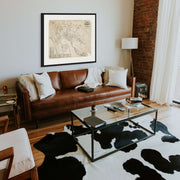 Framed 1886 map of Dunedin, New Zealand displayed on the wall above a sofa in a contemporary living room setting