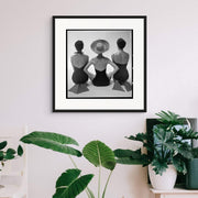 11950s black and white studio photograph featuring three women wearing retro swimwear and flippers, posing in a playful formation.