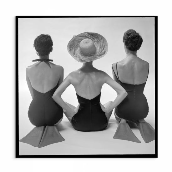 1950s black and white studio photograph featuring three women wearing retro swimwear and flippers, posing in a playful formation.