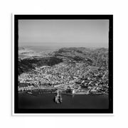 Aerial black-and-white 1950s photograph of Wellington City showing harbour, hills and urban streets.
